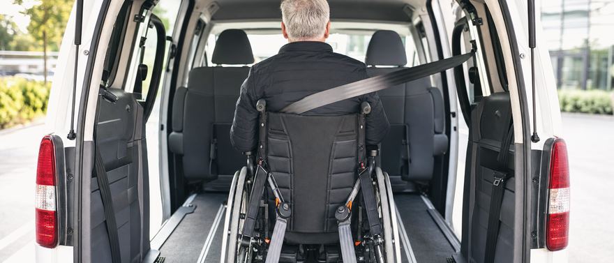 Ein Rollstuhl ist im Van mit Gurten am Boden gesichert.